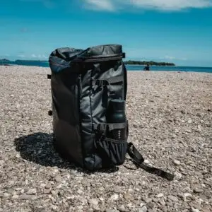 black leather bag on brown rocky beach